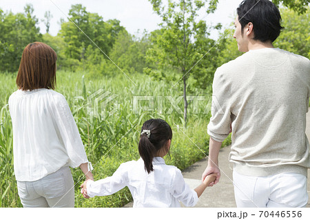 手を繋いで歩く親子 70446556