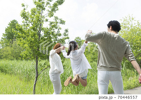手を繋いで歩く親子 70446557