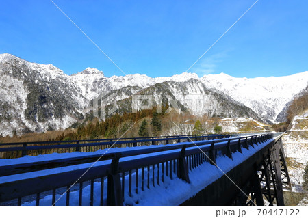 北アルプス連峰と北アルプス大橋 雪景色の写真素材