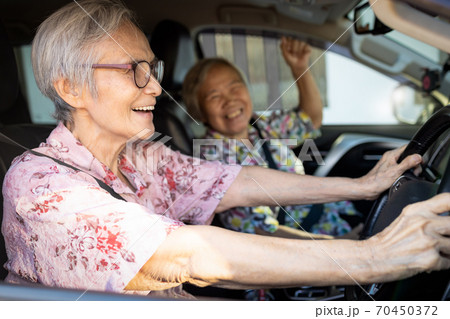 Happy asian senior female driver in her car,enjoy traveling during retirement age with her friend,healthy old people having fun,laughing together,elderly woman driving car,road trip,travel concept Happy asian senior female driver in her car,enjoy traveling during retirement age with her friend,healthy old people having fun,laughing together,elderly woman driving car,road trip,travel concept 70450372