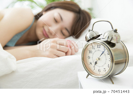 目覚まし時計と女性 70451443