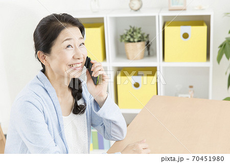 携帯電話で通話する女性 70451980
