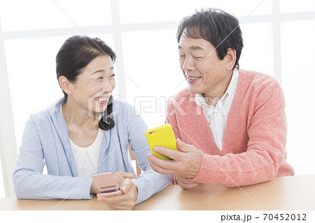 携帯電話を操作する夫婦 70452012