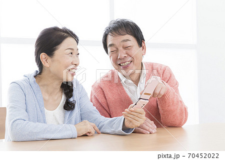 携帯電話を操作する夫婦 70452022