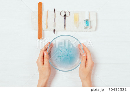 Top view female hands holding bowl of soapy water Top view female hands holding bowl of soapy water 70452521