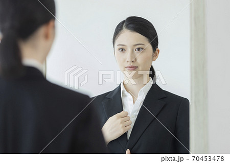 鏡の前に立つリクルートスーツの女性 就活の写真素材