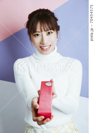 プレゼントを渡す女性 70454575