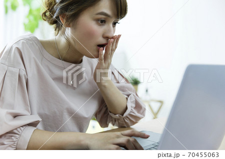 パソコンを見て驚く女性 70455063