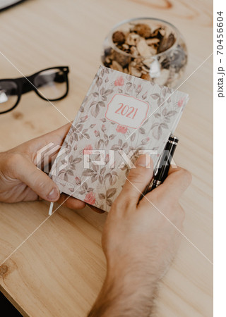 a man sitting at a desk plans the year 2021 a man sitting at a desk plans the year 2021 70456604