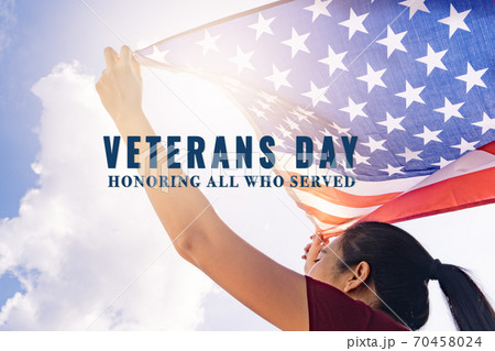 woman holding United States of America flag on sunny sky. Veterans day. Honoring all who served. woman holding United States of America flag on sunny sky. Veterans day. Honoring all who served. 70458024