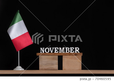 Wooden calendar of November with table Italian flag on black background. Holidays of Italy in November. Wooden calendar of November with table Italian flag on black background. Holidays of Italy in November. 70460595