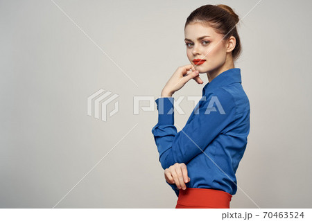 An elegant lady in a blue shirt is gesturing with her hands on a light background and a copy space close-up portrait An elegant lady in a blue shirt is gesturing with her hands on a light background and a copy space close-up portrait 70463524