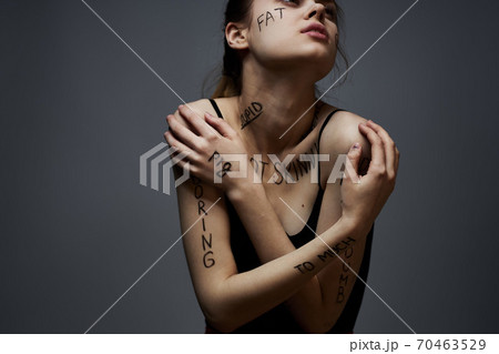 Emotional woman with inscriptions on her body gestures with hands lifestyle frustration stress gray background Emotional woman with inscriptions on her body gestures with hands lifestyle frustration stress gray background 70463529