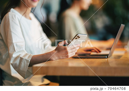 お店でスマホを使う女性の手もと 70464708