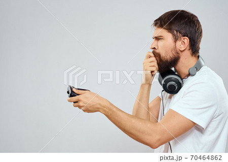 Man with gamepad headphones playing leisure technology white t-shirt light background 70464862