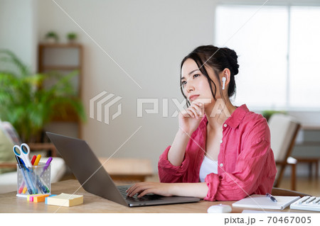 悩みながらテレワークをしている若い女性。 悩みながらテレワークをしている若い女性。 70467005