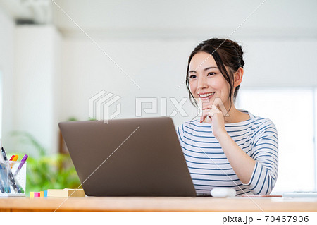 リビングでテレワーク中の女性。 70467906