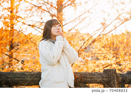 寒がる女性と紅葉　 70468832