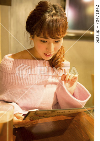 メニューを選ぶ女性 70471942