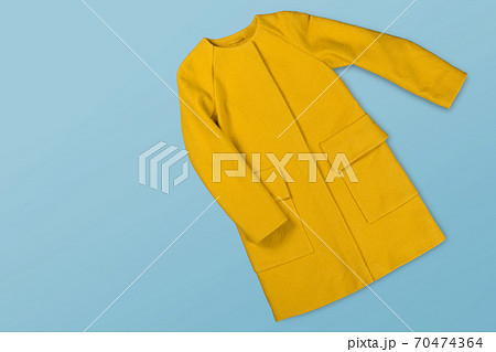 yellow woolen female coat on a blue background, concept of shopping and fashion 70474364