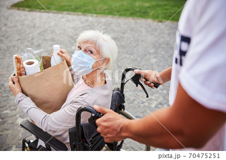 Curious lady looking at the person helping her during the pandemic Curious lady looking at the person helping her during the pandemic 70475251