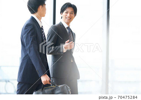 話しながら歩く2人のビジネスマン 話しながら歩く2人のビジネスマン 70475284