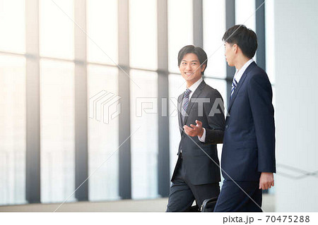 話しながら歩く2人のビジネスマン 70475288