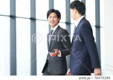 話しながら歩く2人のビジネスマン 70475289