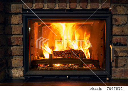fireplace and fire close view as object or background, brick wall 70476394