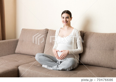 Young pregnant woman holds wooden heart. Love concept 70476686