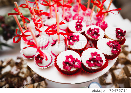 Delicious and tasty dessert table with cupcakes shots at reception closeup Delicious and tasty dessert table with cupcakes shots at reception closeup 70476714