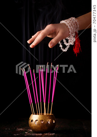 Hand with rosary over smoke, reiki concept 70477345