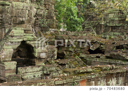 Old stone temple ruin of Angkor in Cambodia, closeup. Stone overgrown with ancient huge tree roots 70483680