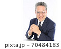 にこやかな笑顔でテーブルに肘を置くビジネスマン 70484183