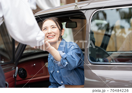 男性のエスコートで車を降りる女性の写真素材