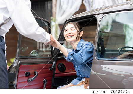 男性のエスコートで車を降りる女性の写真素材