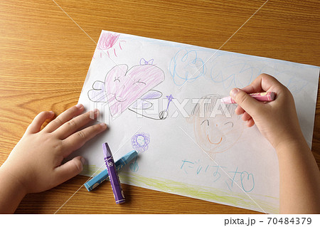 右利きの子供が描いた絵とクレヨンを持つ手の一部分のカット 右利きの子供が描いた絵とクレヨンを持つ手の一部分のカット 70484379