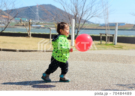 赤い風船を持って楽しそうにしている子供 赤い風船を持って楽しそうにしている子供 70484489