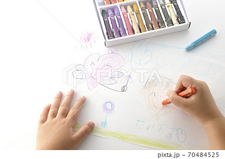 右利きの子供が描いた絵とクレヨンを持つ手の一部分のカット(白背景) 右利きの子供が描いた絵とクレヨンを持つ手の一部分のカット(白背景) 70484525
