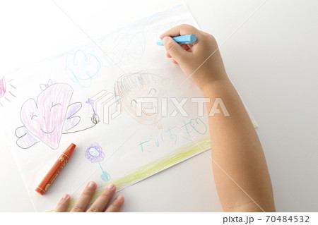 右利きの子供が描いた絵とクレヨンを持つ手の一部分のカット(白背景) 右利きの子供が描いた絵とクレヨンを持つ手の一部分のカット(白背景) 70484532