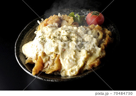 ミニトマトなど野菜も一緒に乗っているタルタルソースたっぷりの熱々チキン南蛮丼（黒背景） 70484730