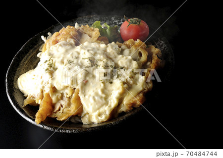 ミニトマトなど野菜も一緒に乗っているタルタルソースたっぷりの熱々チキン南蛮丼(黒背景) ミニトマトなど野菜も一緒に乗っているタルタルソースたっぷりの熱々チキン南蛮丼(黒背景) 70484744