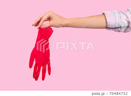 Female hand holding a pink rubber glove Female hand holding a pink rubber glove 70484752
