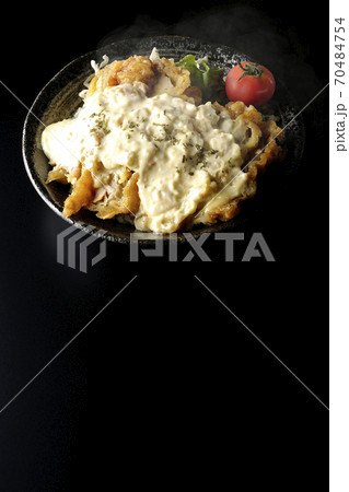 ミニトマトなど野菜も一緒に乗っているタルタルソースたっぷりの熱々チキン南蛮丼(黒背景) ミニトマトなど野菜も一緒に乗っているタルタルソースたっぷりの熱々チキン南蛮丼(黒背景) 70484754