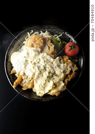 ミニトマトなど野菜も一緒に乗っているタルタルソースたっぷりの熱々チキン南蛮丼(黒背景、俯瞰) ミニトマトなど野菜も一緒に乗っているタルタルソースたっぷりの熱々チキン南蛮丼(黒背景、俯瞰) 70484910
