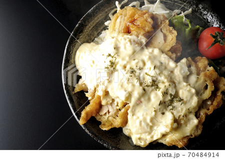 ミニトマトなど野菜も一緒に乗っているタルタルソースたっぷりの熱々チキン南蛮丼(黒背景、俯瞰) ミニトマトなど野菜も一緒に乗っているタルタルソースたっぷりの熱々チキン南蛮丼(黒背景、俯瞰) 70484914