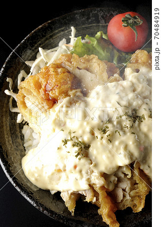 ミニトマトなど野菜も一緒に乗っているタルタルソースたっぷりの熱々チキン南蛮丼(黒背景、俯瞰) ミニトマトなど野菜も一緒に乗っているタルタルソースたっぷりの熱々チキン南蛮丼(黒背景、俯瞰) 70484919