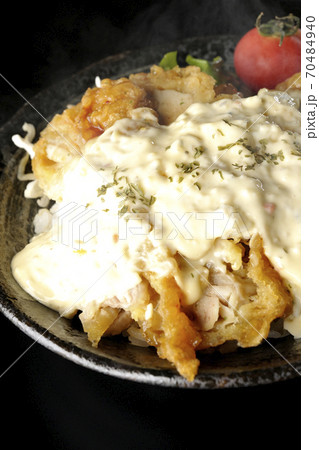 ミニトマトなど野菜も一緒に乗っているタルタルソースたっぷりの熱々チキン南蛮丼(黒背景) ミニトマトなど野菜も一緒に乗っているタルタルソースたっぷりの熱々チキン南蛮丼(黒背景) 70484940