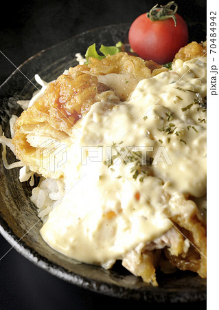 ミニトマトなど野菜も一緒に乗っているタルタルソースたっぷりの熱々チキン南蛮丼（黒背景） 70484942