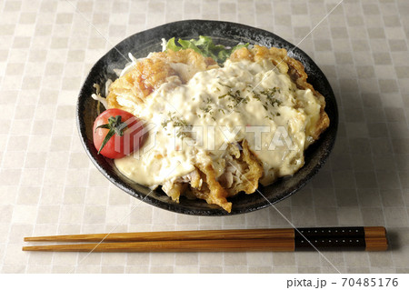 ミニトマトなど野菜も一緒に乗っているタルタルソースたっぷりの熱々チキン南蛮丼とお箸 70485176